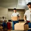 mid-adult-worker-carrying-cardboard-bo